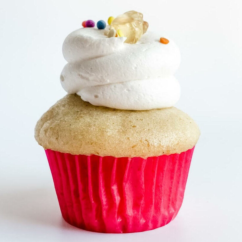 Vanilla cupcake, topped with vanilla buttercream and sprinkles and a gummie bear.